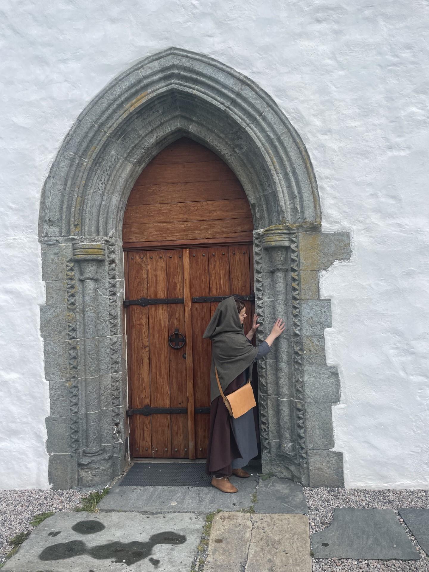 Pilgrim foran kirkedør i sør